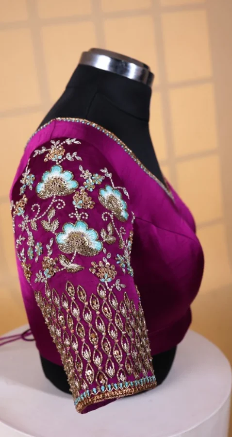 Atelier photograph standing in for the Pearl Zardosi Motifs: a magenta silk blouse on a dress form, gold and pale blue hand work covering the sleeve